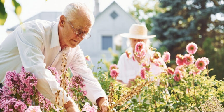 Elderly Couple Tending to Flowers in a Garden at a Memory Care Facility
