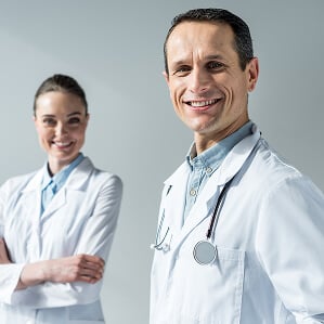 Smiling Male and Female Nursing Staff in White Coats Smiling Male and Female Nursing Staff in White Coats