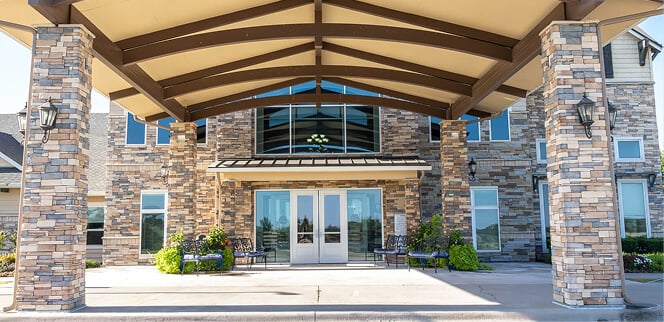 Welcoming Covered Stone Entrance with Benches and Seasonal Flowers Welcoming Covered Stone Entrance with Benches and Seasonal Flowers